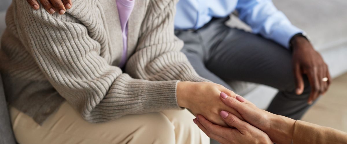 Warmly holding person's hand during marriage therapy session