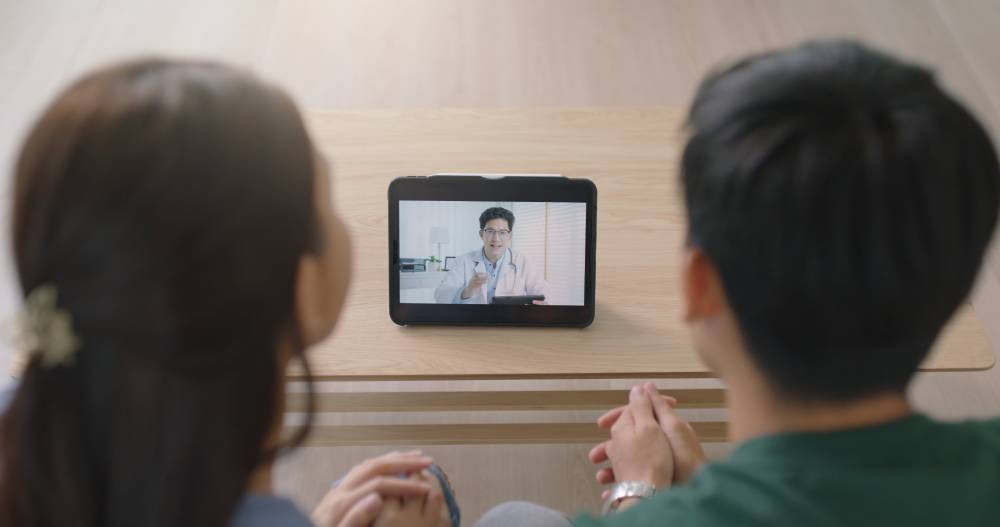 2342605945 A couple talking to a doctor via video call during an online therapy.